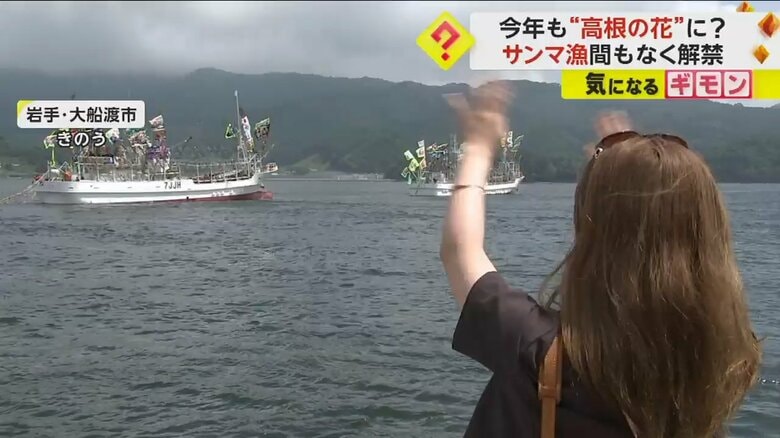 漁船に手を振って見送る