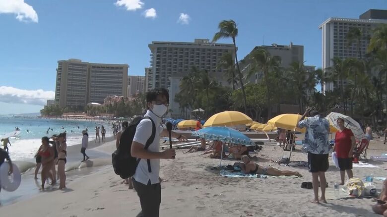 人であふれるワイキキビーチ。マスクをした取材クルーは浮いていた