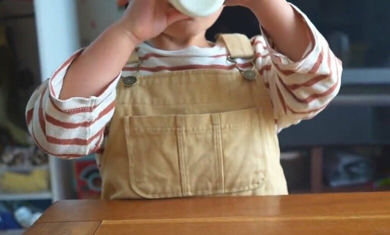 自分で注いだ牛乳を飲む息子さん