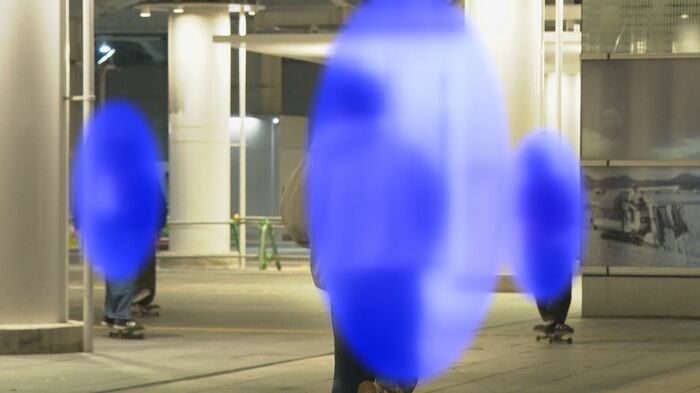 パトカーに気付き走り去るスケートボーダー