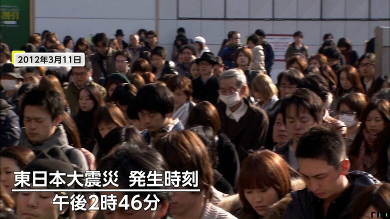 東日本大震災の1年後にアルタ前で黙とうを捧げる人々