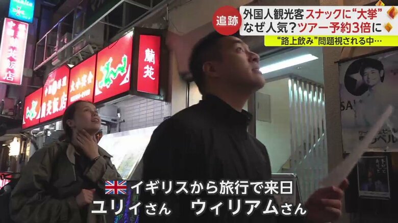 “スナックツアー”に参加した2人。漢字で店の名前が書かれた紙を手に、店を探す