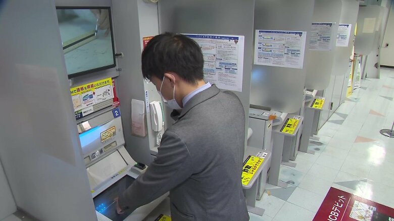 右手に携帯電話を持ちATMを操作すると…