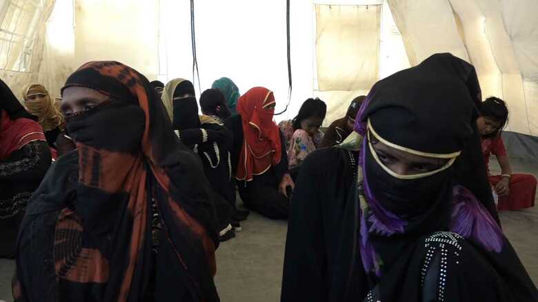 写真左の女性は、インタビューに答えてくれた少女（右）の母親