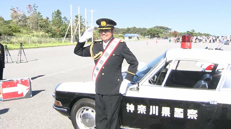 パトカーの前でポーズを決める近藤さん
