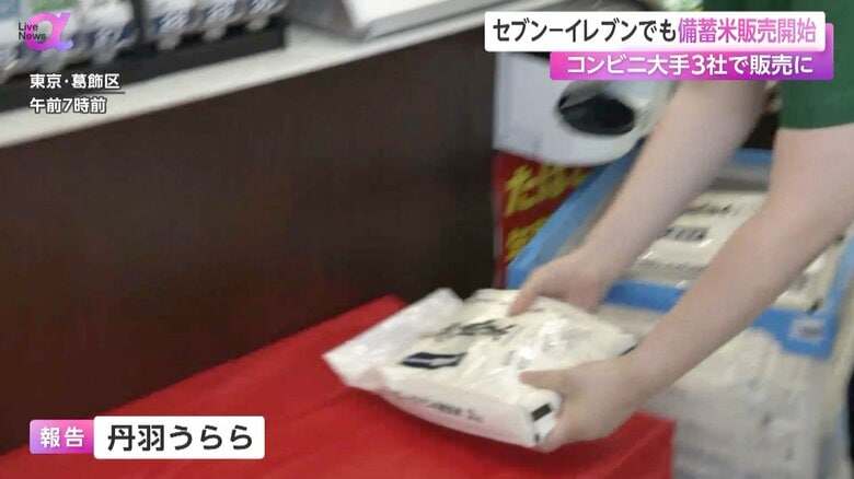 店頭に無洗米の備蓄米を陳列するセブン‐イレブンの従業員