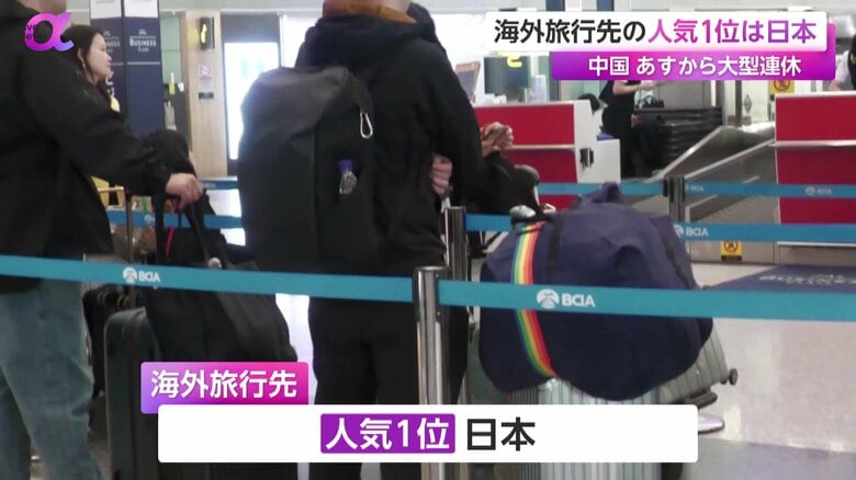 大きな荷物を手に、カウンター前に並ぶ中国人旅行客の姿