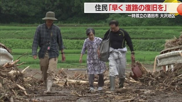 泥にまみれた橋を渡る高齢女性たち