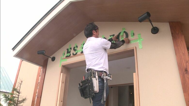 店の入口に「復活の象徴」を取り付け