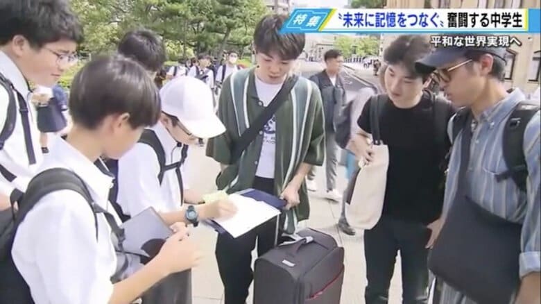 生徒たちの呼びかけに足を止める東京からの観光客