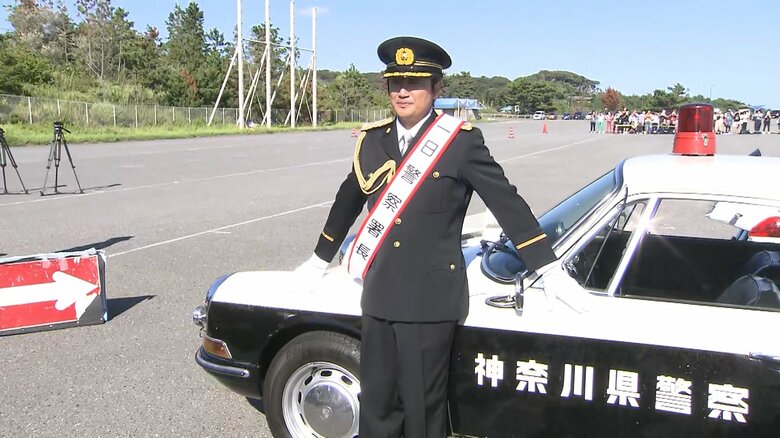パトカーの前でポーズを決める近藤さん