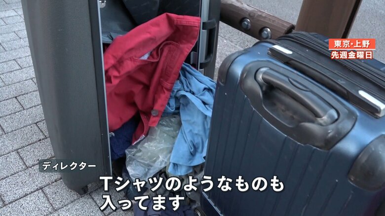 スーツケースから飛び出した衣類が散乱