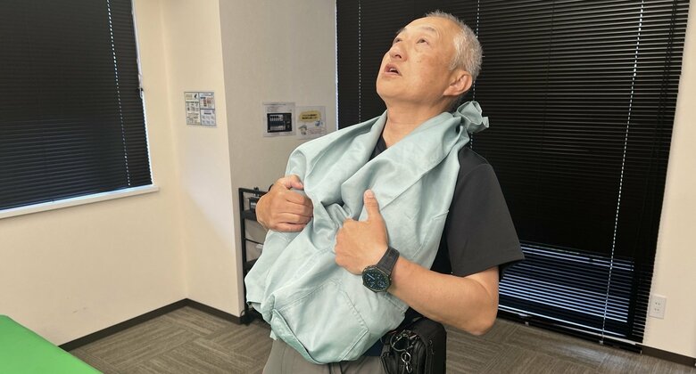 裾を上に頭からかぶりネクタイで腰に固定（特集班撮影）