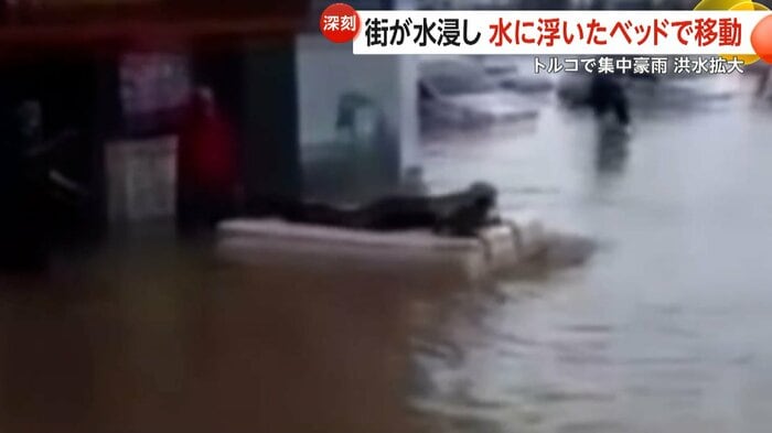 ベッドに乗り水の上を移動する人