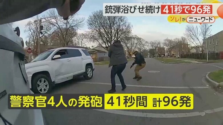 白い車に乗った男に銃を向ける警察官