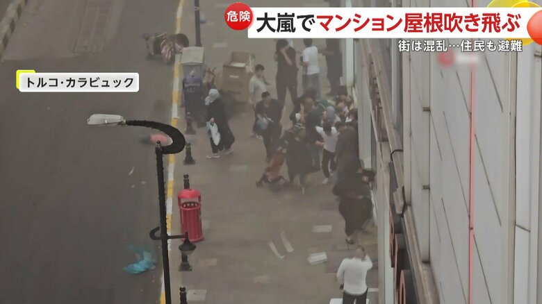 トルコ北部カラビュックで、体をかがめて建物の中へと避難する人たち