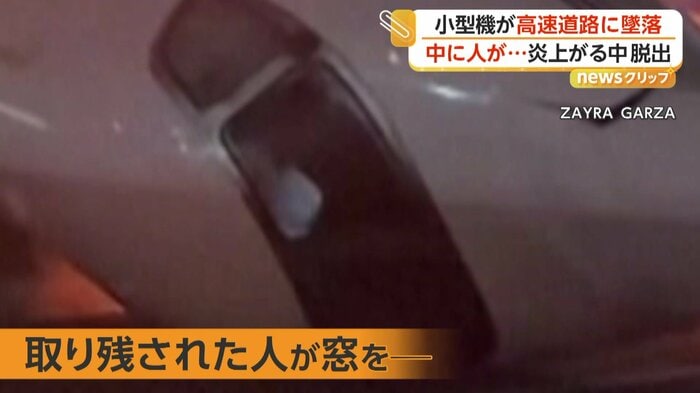機内から窓を叩く人