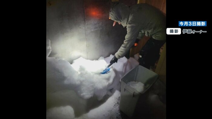 室内に積もった雪を外に運び出す