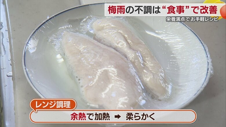 白い皿にラップで包まれた鶏むね肉を加熱調理している様子
