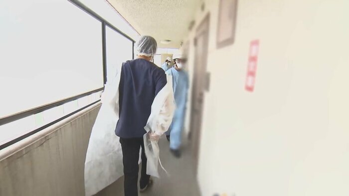 緊急の依頼を受け、防護服を着込んで酸素濃縮器を運び込む