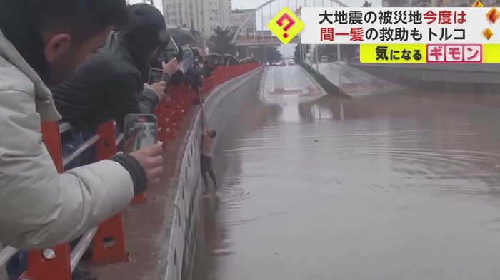 岸にたどり着き、引き上げられる男性(画像:IHAより)
