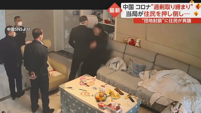 住民をソファに押し倒す責任者らしき人物