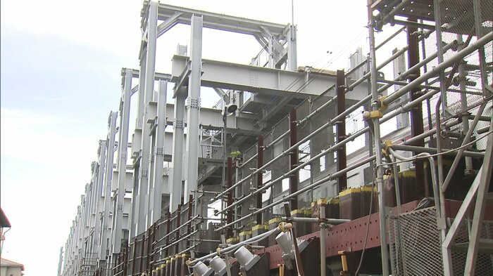 高架工事の脇を列車が通過している