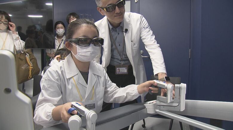 3Dメガネかけてアームを操作…小学生が手術支援ロボット「Hugo」を使い内視鏡手術を体験 愛知・藤田医科大学｜FNNプライムオンライン