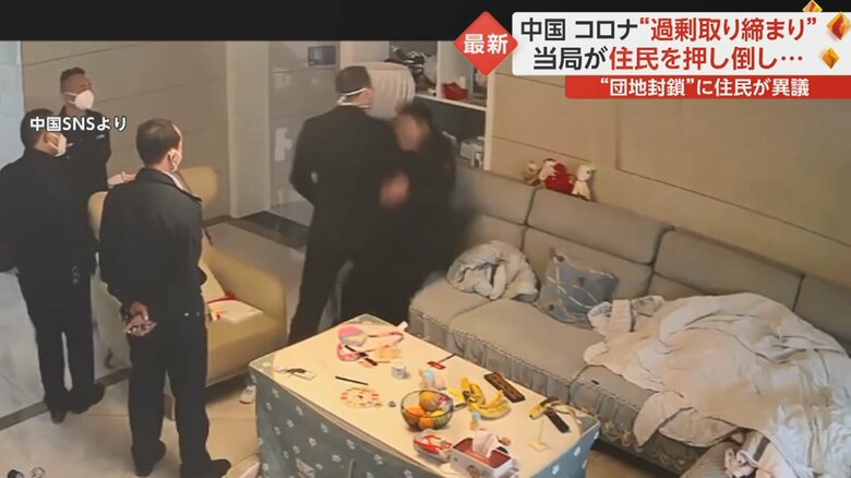住民をソファに押し倒す責任者らしき人物