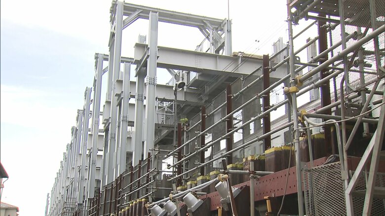 高架工事の脇を列車が通過している