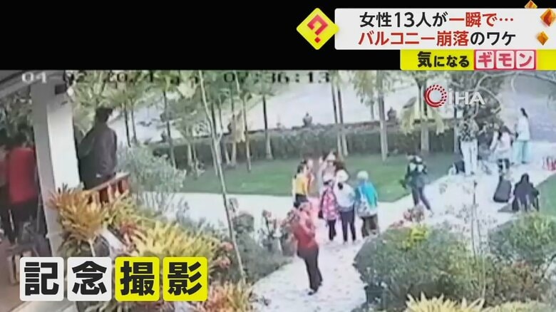 地上からバルコニーにカメラを向ける人