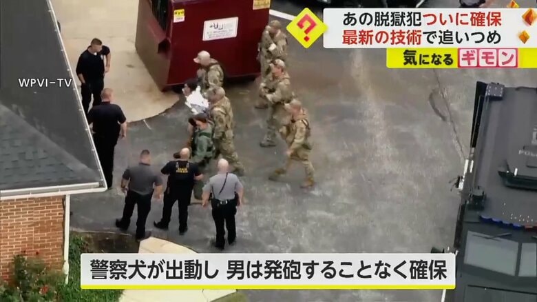 警察官たちに確保され、連行される脱獄犯の男