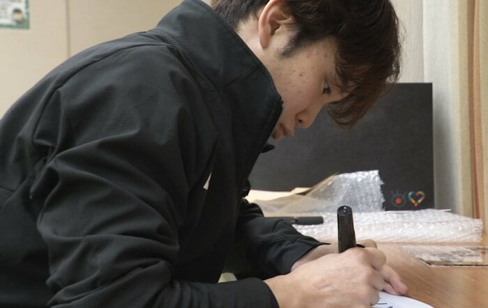 キスクラに飾られる全日本の意気込みを書く友野（2025年11月）