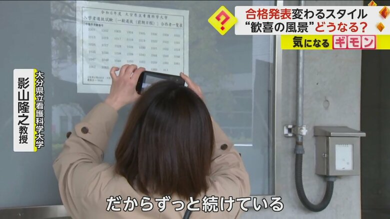 張り出された番号をスマホで撮影する人