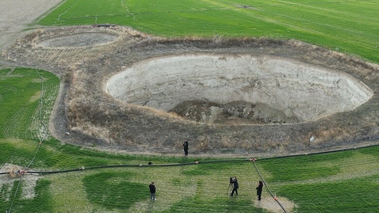 トルコ中部・コンヤ　陥没穴のそばで取材中の記者