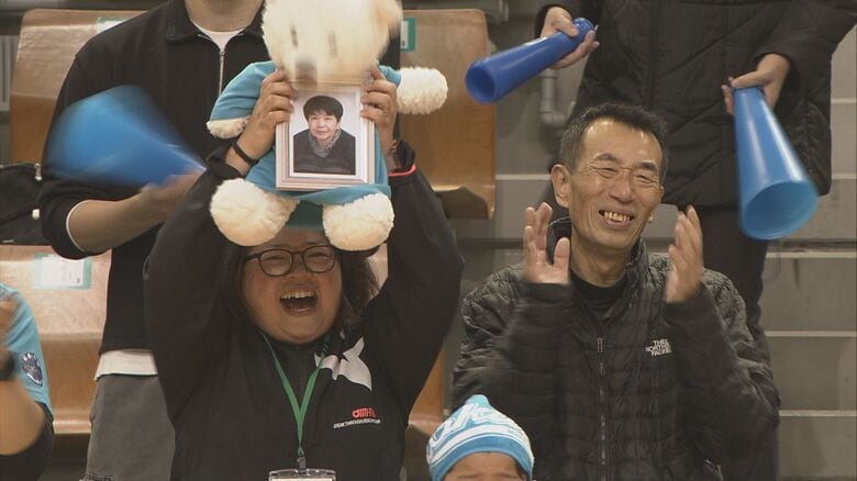 応援席　遺影を掲げる