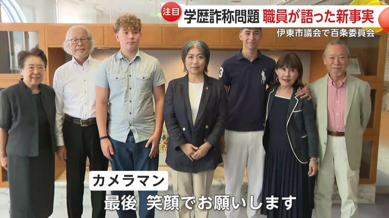 固い表情のまま留学生と写真撮影