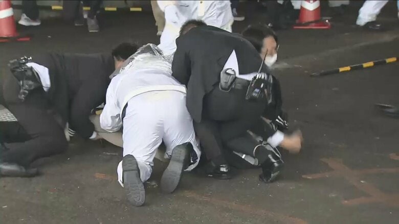 容疑者を取り押さえる警察官