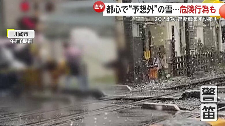 警報音が鳴る中、遮断機をすり抜け、20人以上が踏み切りを横断