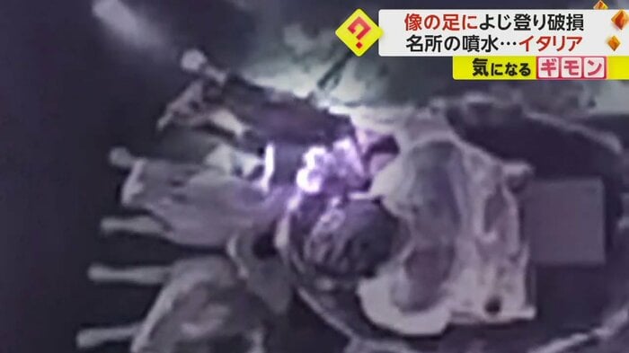 像の足元に座り込んで、両足を伸ばす男性