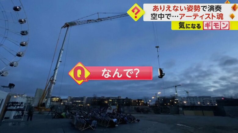 クレーンに釣られ、空に宙吊りになるピアノ