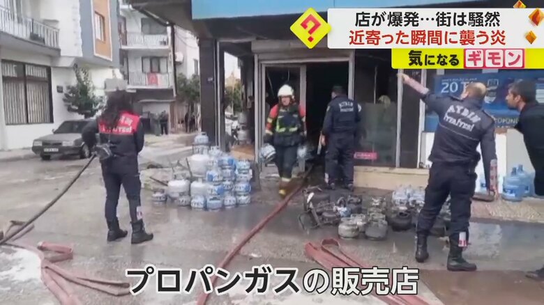 爆発のあった店の中から真っ黒になったガスボンベが運び出される様子