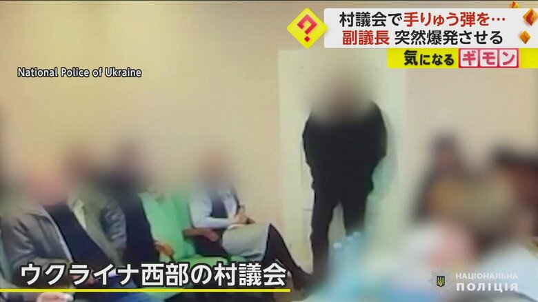 黒い服を着てドアの前に立つ副議長の男