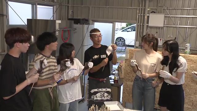 学生たちに串の刺し方を教える管野さん