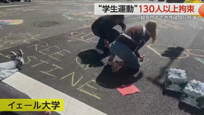 地面に文字や絵を書いているイェール大学の学生
