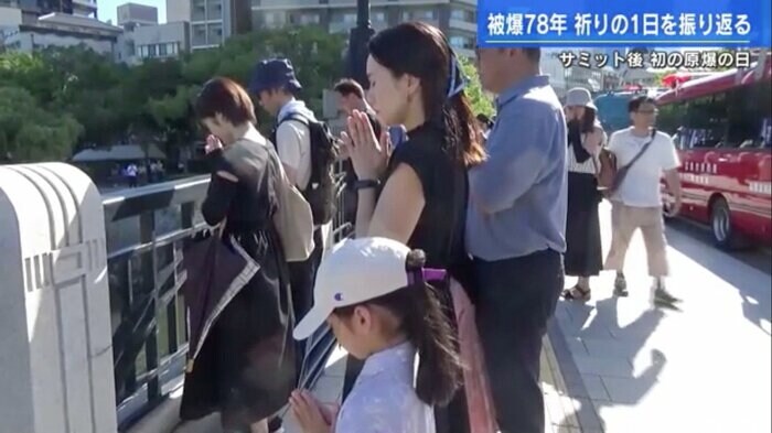 元安川にかかる橋の上で黙とうする人々
