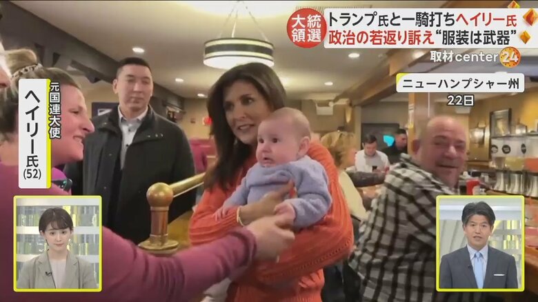 オレンジ色のセータを着て赤ちゃんをあやすヘイリー氏の様子