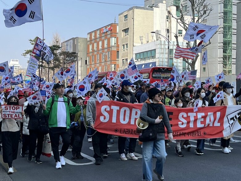 「STOP THE STEAL」の垂れ幕を掲げる尹支持派