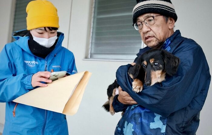 言葉少なげにりんを抱きしめていた(写真提供:ピースワンコ・ジャパン)