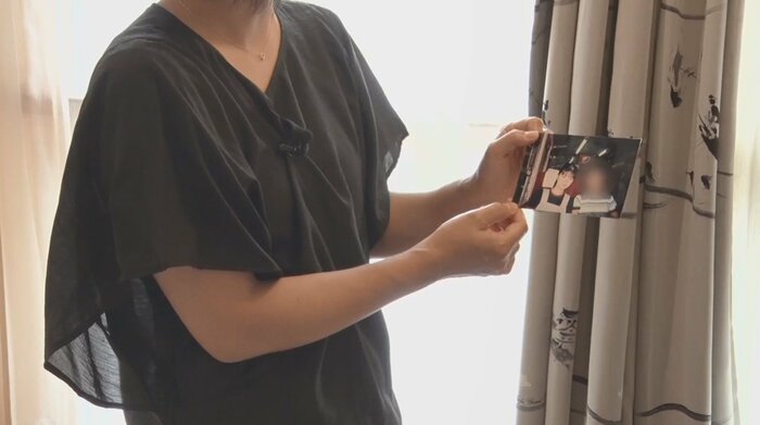 亡くなった小林順子さんの写真を手に取材に応じる姉・亜希子さん